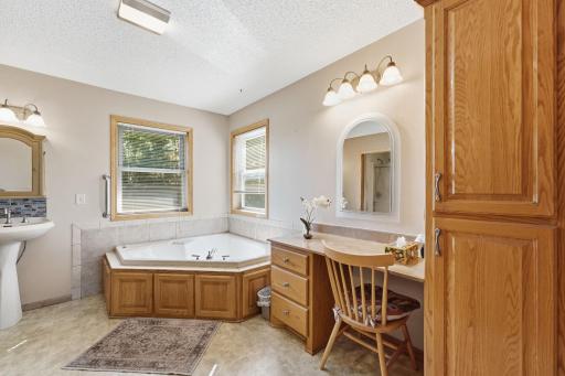 Jetted tub and makeup area in primary bathroom.