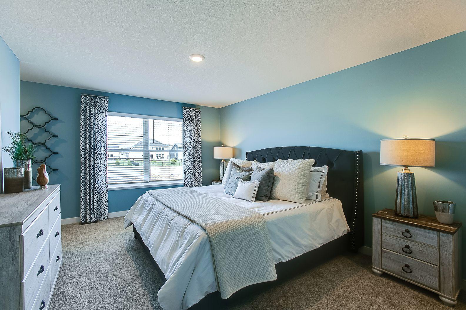 Unwind after a long day in your upper level primary suite with attached bath. Color and options will vary.