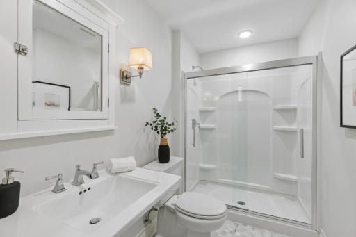 Lower-level 3/4 bath featuring tiled floors and a practical layout.