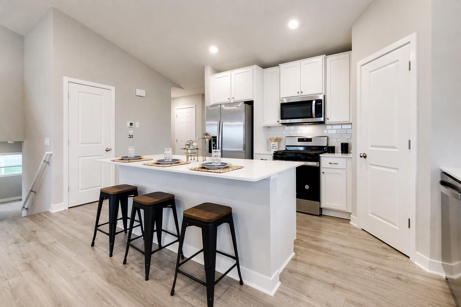 Gorgeous kitchen with large center island and nice pantry for storage. Stainless appliances, walk-in pantry, quartz counters, and subway backsplash! Photo of Model Home. Options and colors may vary. Ask Sales Agent for details.