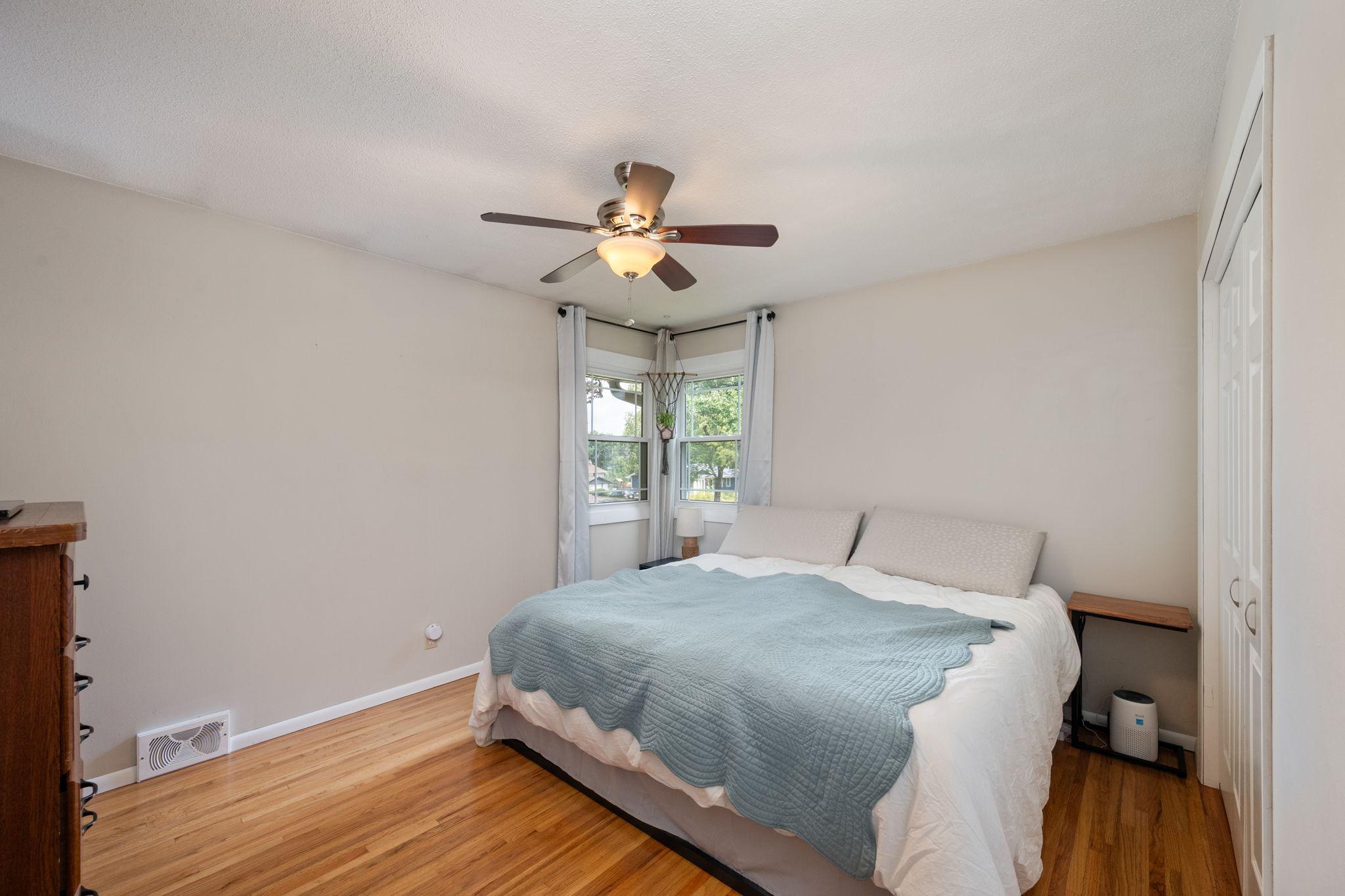 Primary Bedroom with corner windows, ceiling fan and en-suite bathroom