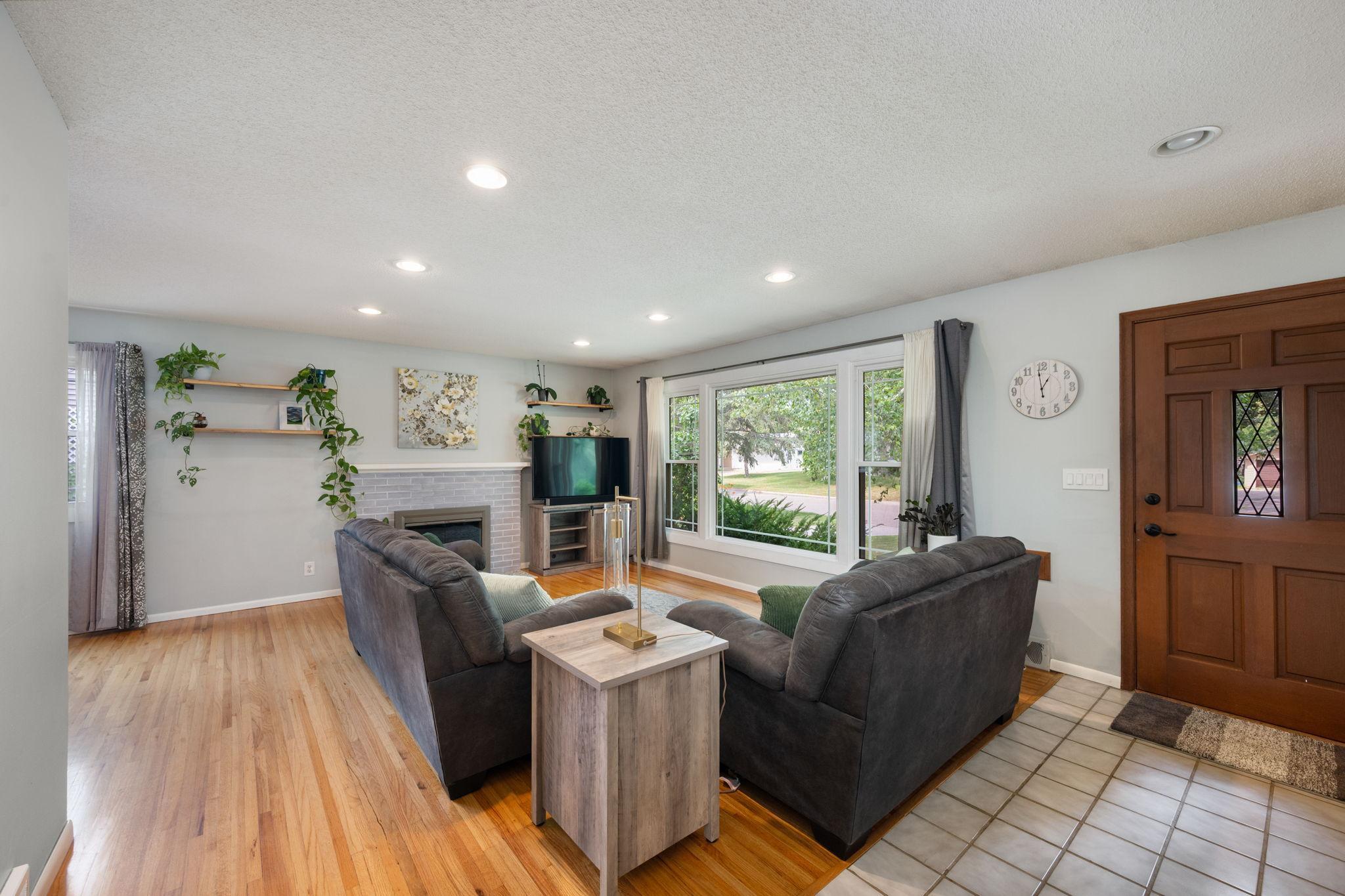 Main floor living room with a large picture window bringing nature light inside