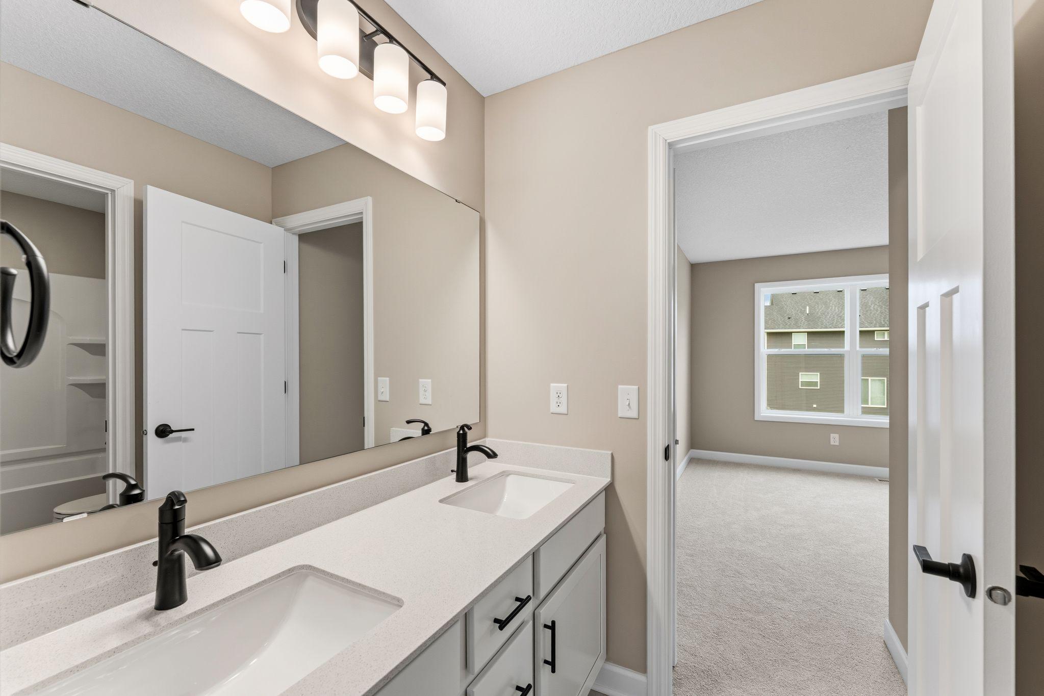 This full size Jack and Jill bathroom connects two of the upper level secondary bedrooms
