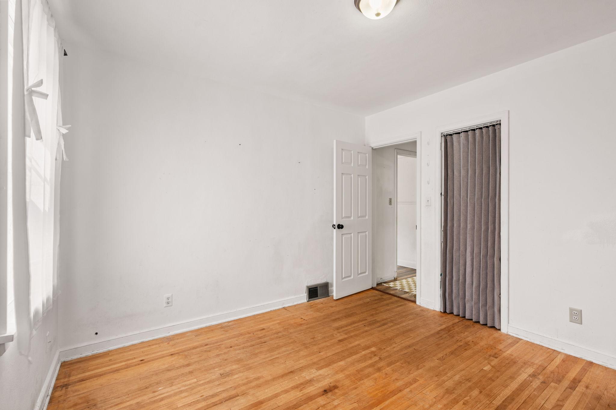 Bright bedroom with hardwood floors and neutral finishes.