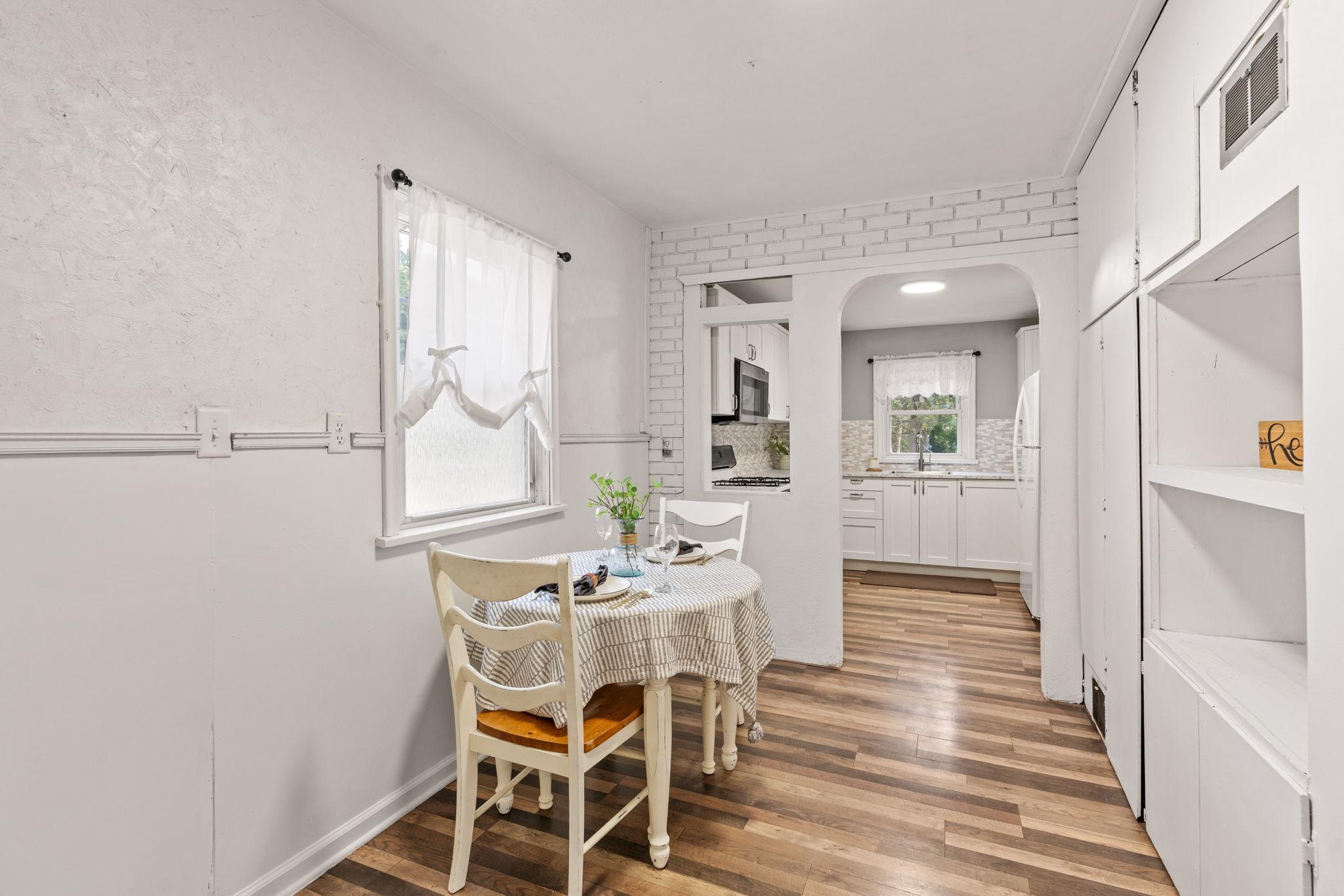 Charming dining nook with built-in shelving and easy kitchen access.