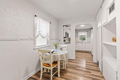 Charming dining nook with built-in shelving and easy kitchen access.