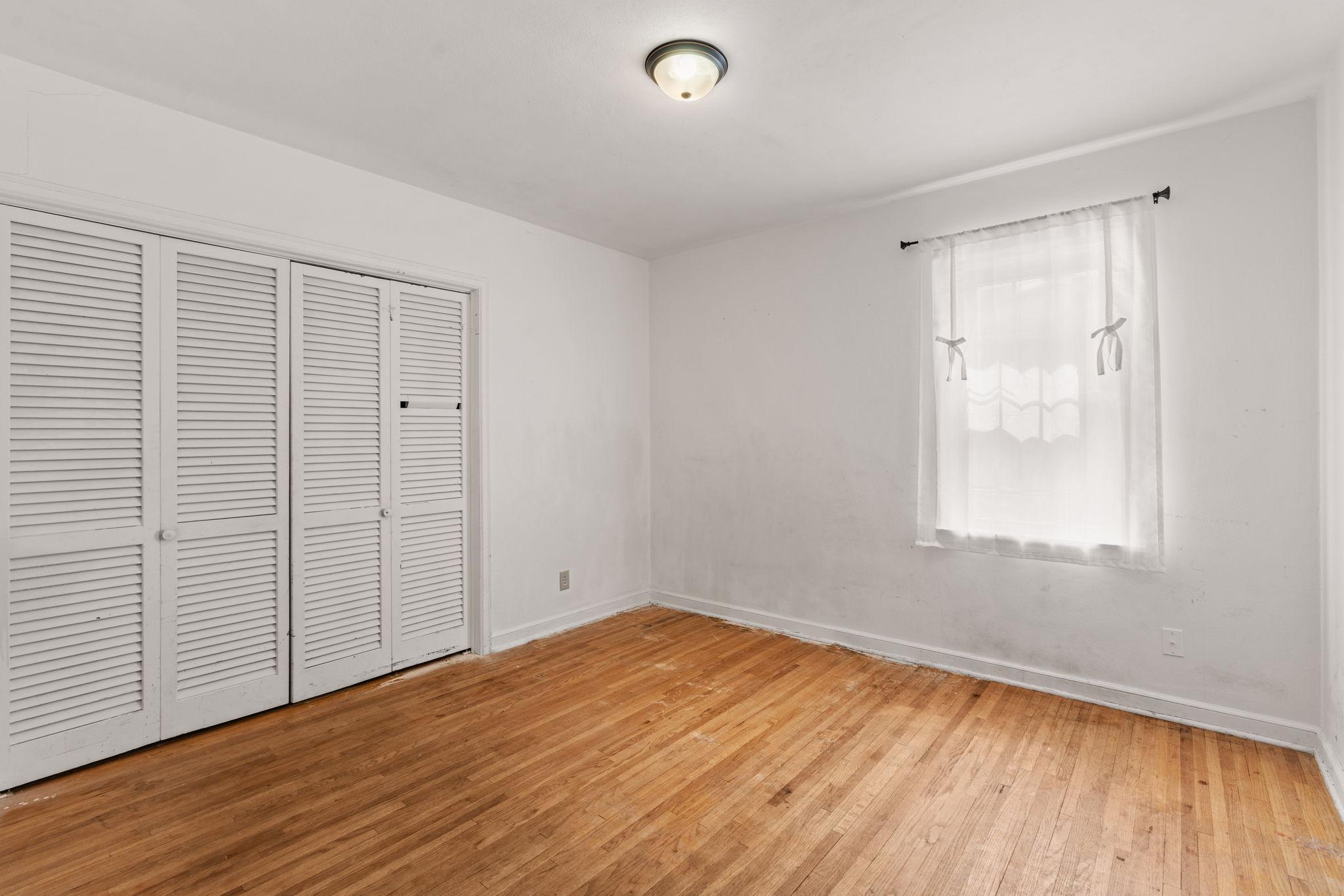Main-level bedroom with hardwood floors and closet.