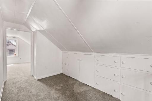 Upper-level space with built-in drawers and charming sloped ceilings.