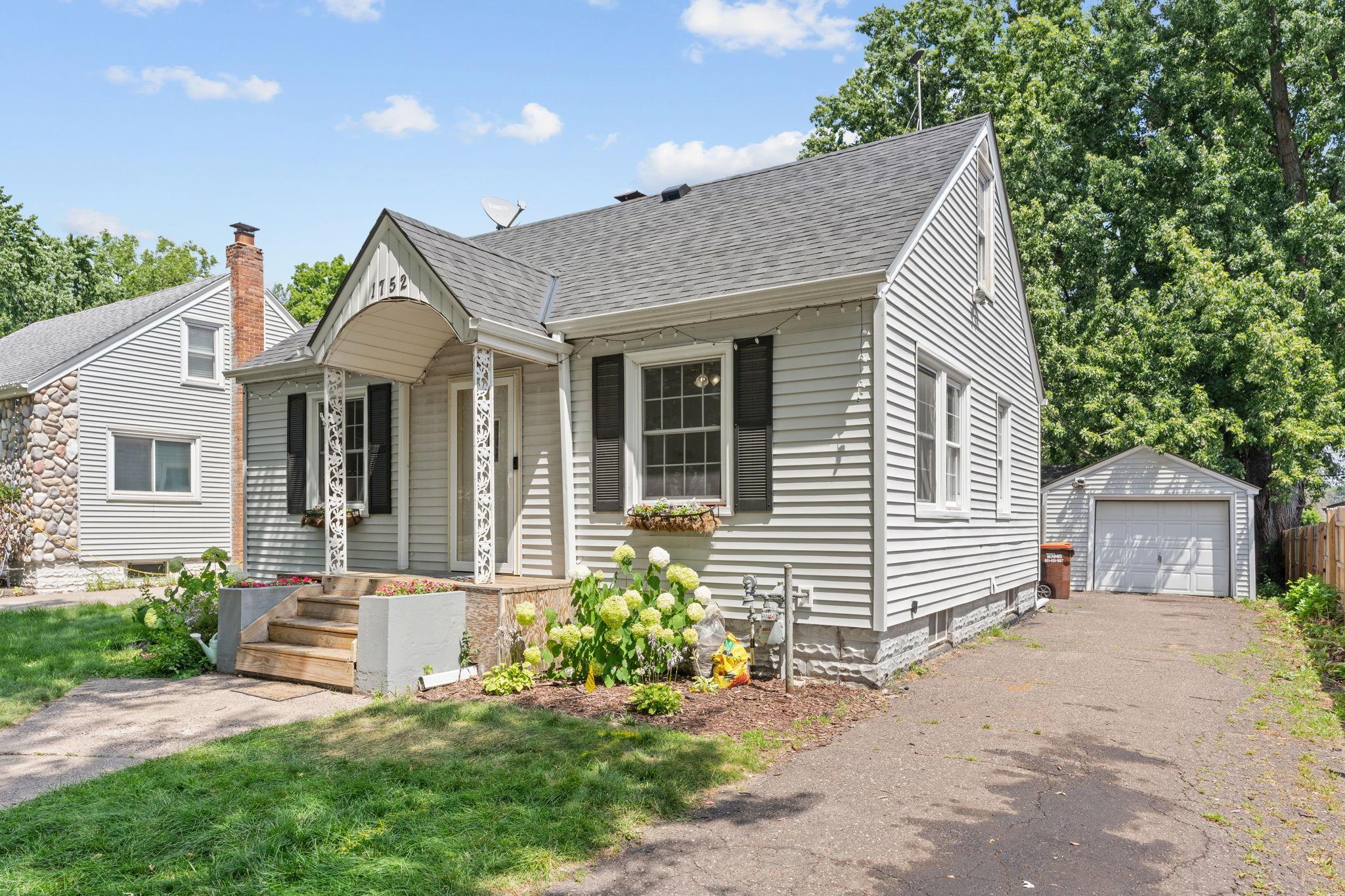 Charming front exterior featuring new low-maintenance siding, a new roof, and established landscaping.