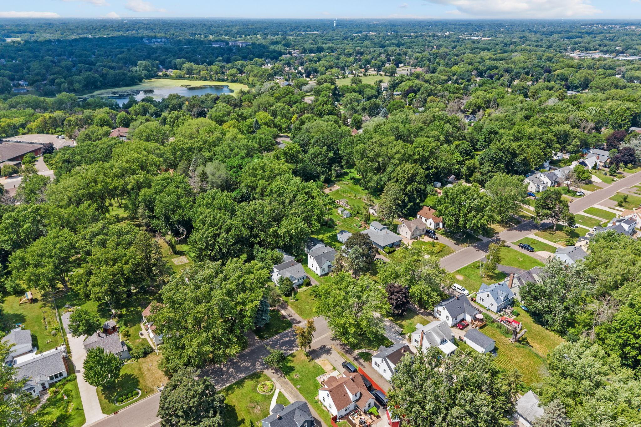Aerial perspective highlights the new roof, exceptionally deep lot, and surrounding greenery.
