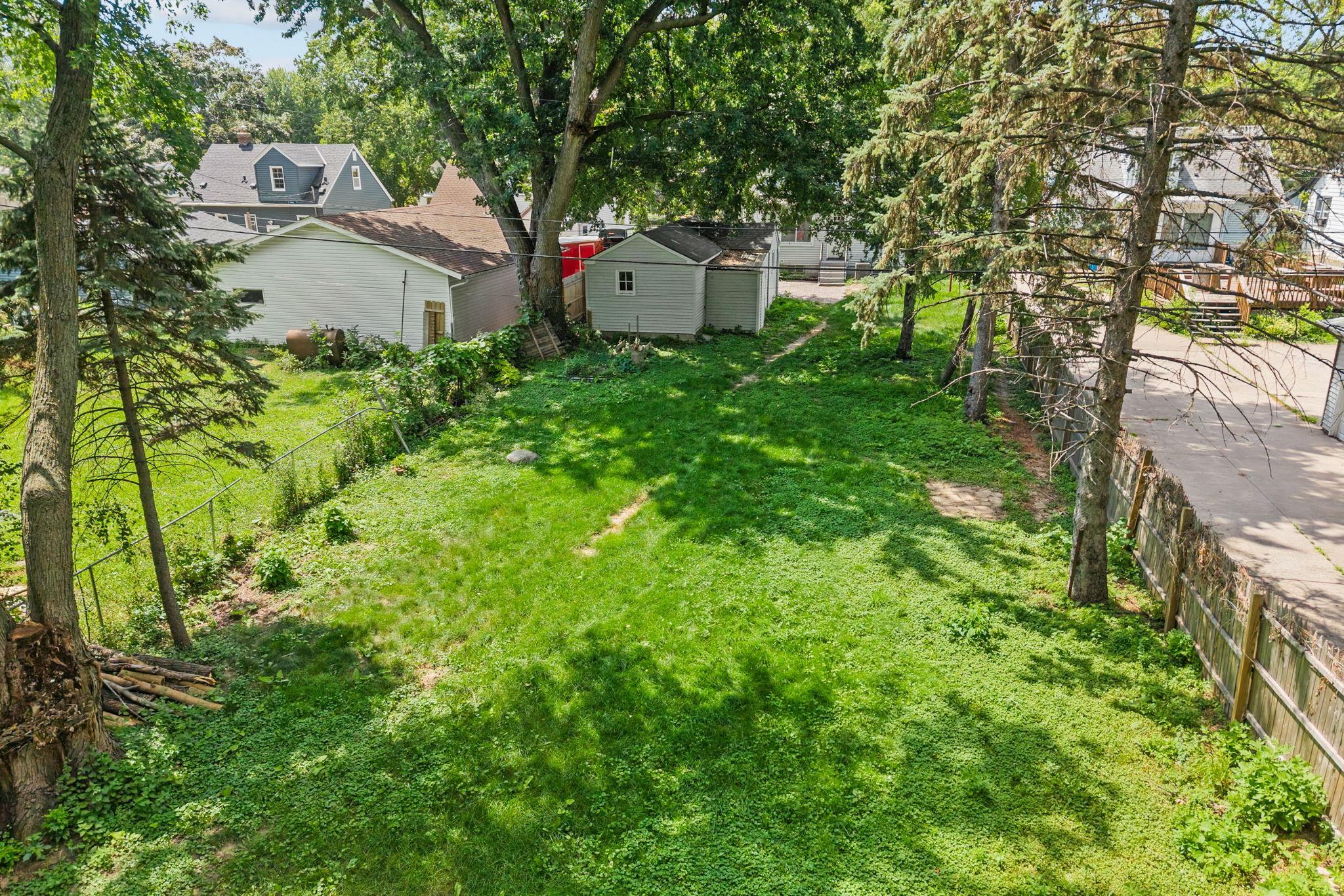 Fenced in with mature trees and abundant green space create a peaceful backyard oasis.