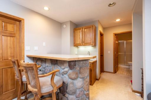 Wet bar in the lower level has matching stone from the nearby fireplace
