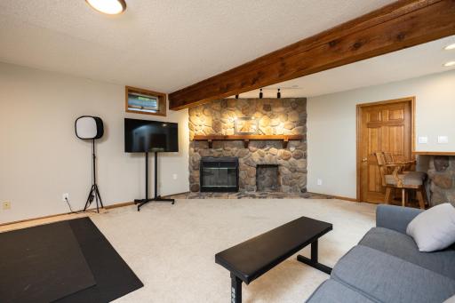 Spacious lower level family room, anchored by the floor to ceiling stone fireplace