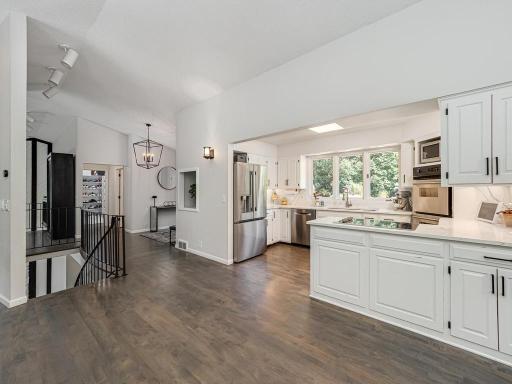 The functional updated open kitchen features new countertops and appliances (both in 2025) a cooktop, a double oven and a convenient beverage counter (also new in 2025).