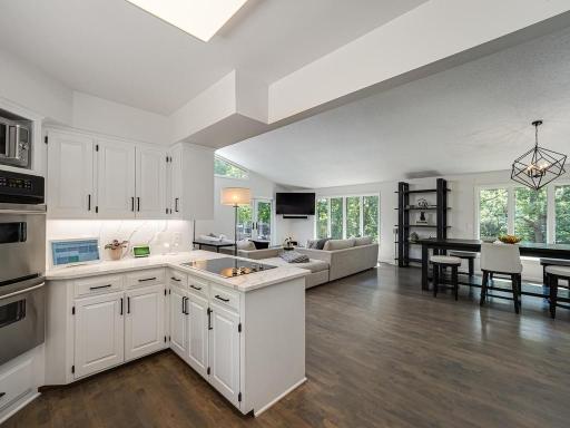 "This photo and the last two photos" show the nice cabinet and countertop space. Note also more of the openness of the main floor and more of the hardwood floors. The hardwood floors were put in in 2019 with a color that was ahead of its its time.