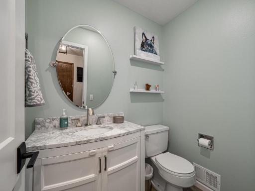 The half bath (with a new vanity in 2022) as you enter this home from the garage.