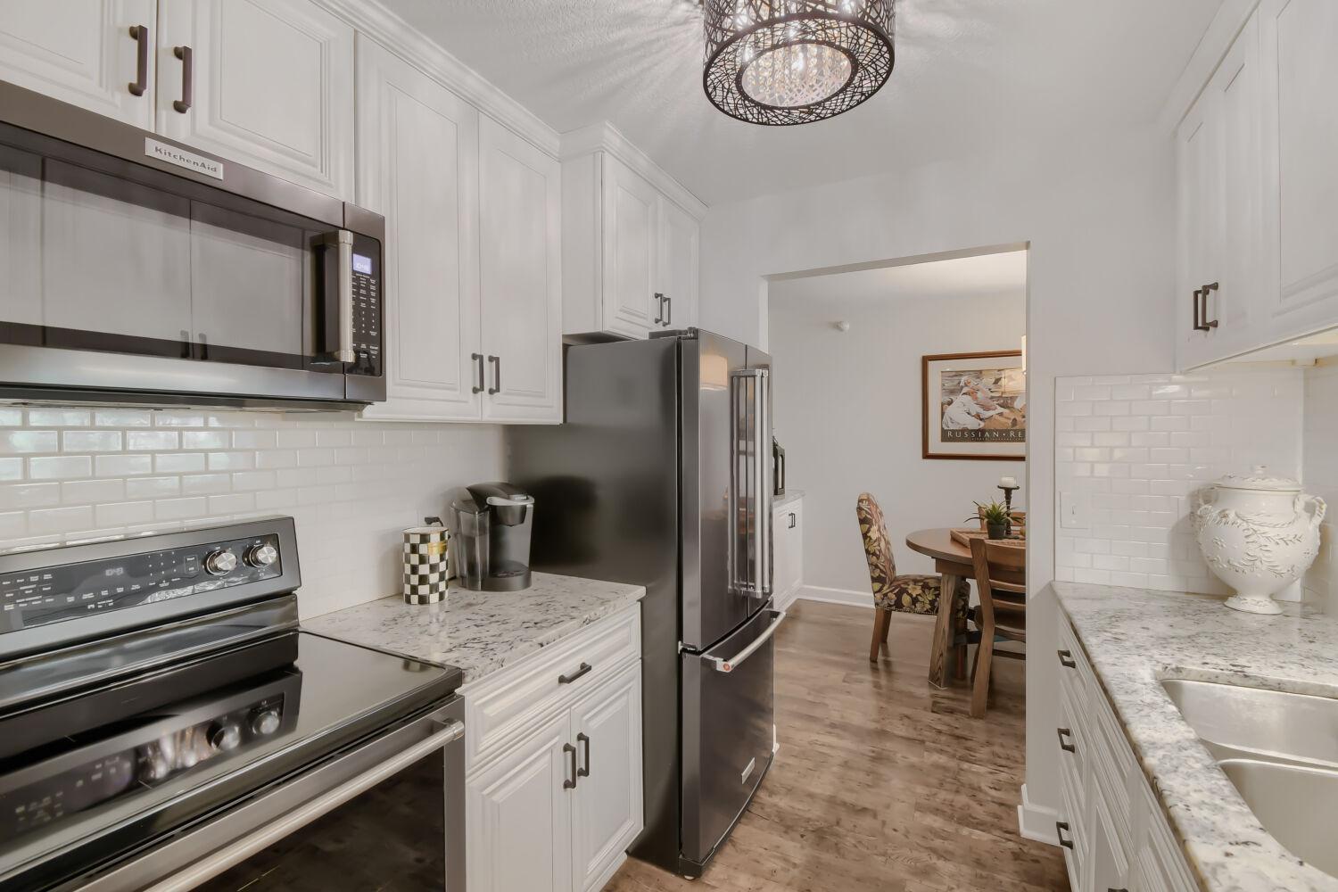 Stainless steel appliances include smooth cooktop range oven, refrigerator, microwave and dishwasher.