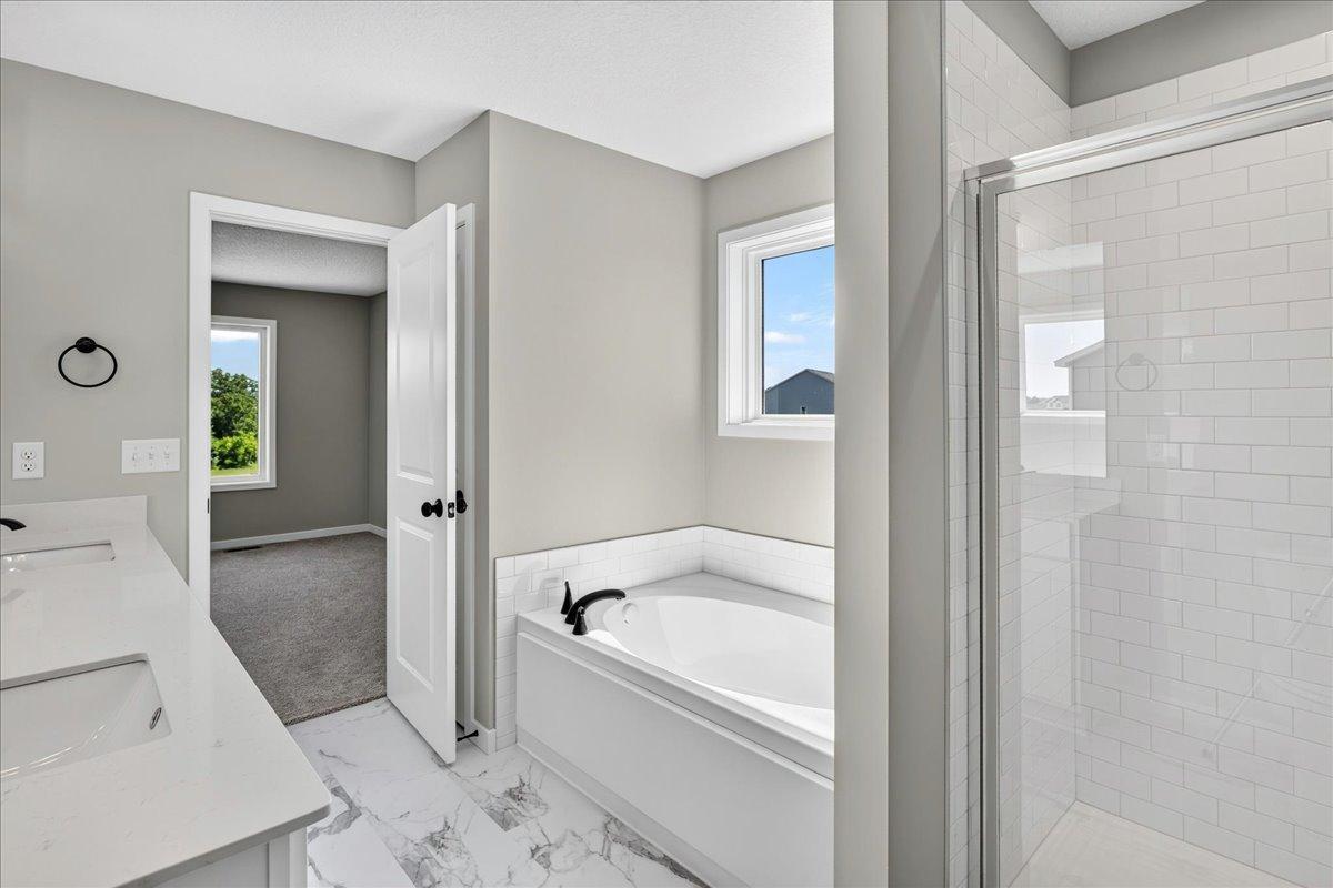 PHOTO OF A DIFFERENT HOME WITH SIMILAR PLAN AND FINISHES. Upper Primary Deluxe Bathroom features a Soaking Tub, Separate Shower, and Linen Closet.