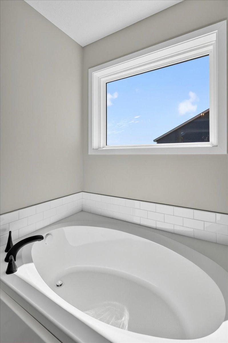 PHOTO OF A DIFFERENT HOME WITH SIMILAR PLAN AND FINISHES. Primary Deluxe Bath Soaking Tub.