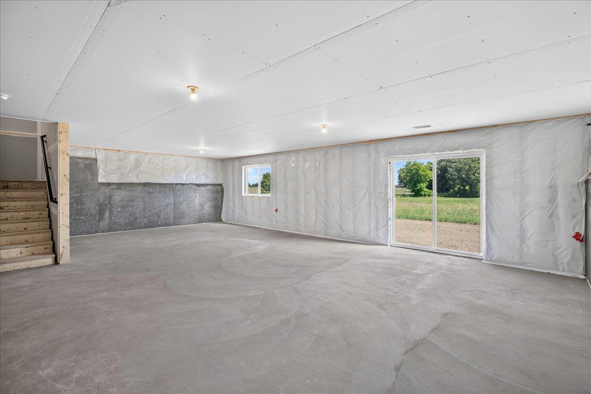 PHOTO OF A DIFFERENT HOME WITH SIMILAR PLAN AND FINISHES. Unfinished Walkout Lower Level ready for future finish including future family room, bedroom 5, bathroom 4, and storage.