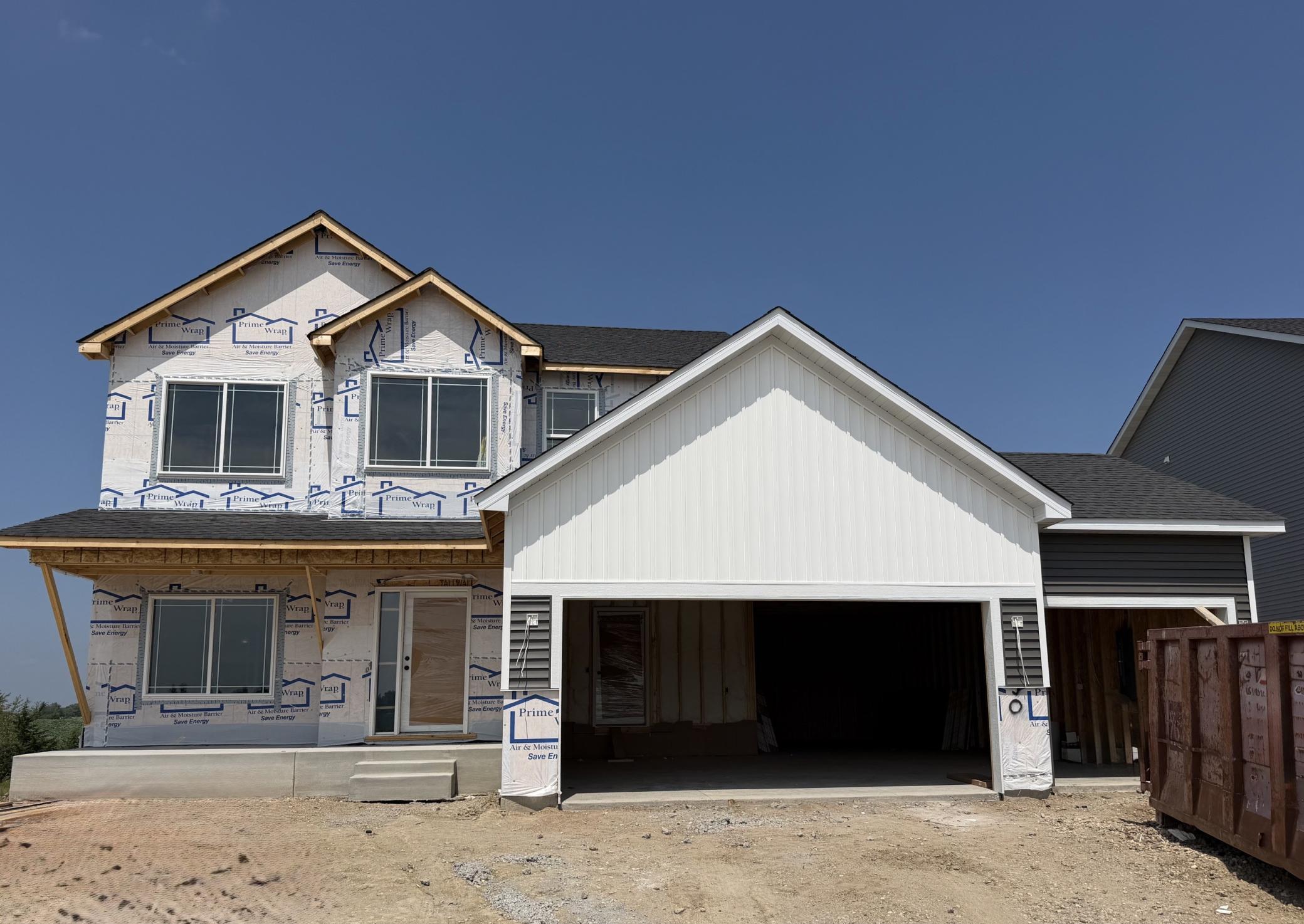 9650 32nd St NE- Photo of actual home under construction offering an estimated September move-in. Front porch columns and siding will be installed soon. Highlights include a 4 BAY GARAGE on a WALKOUT CORNER HOMESITE!