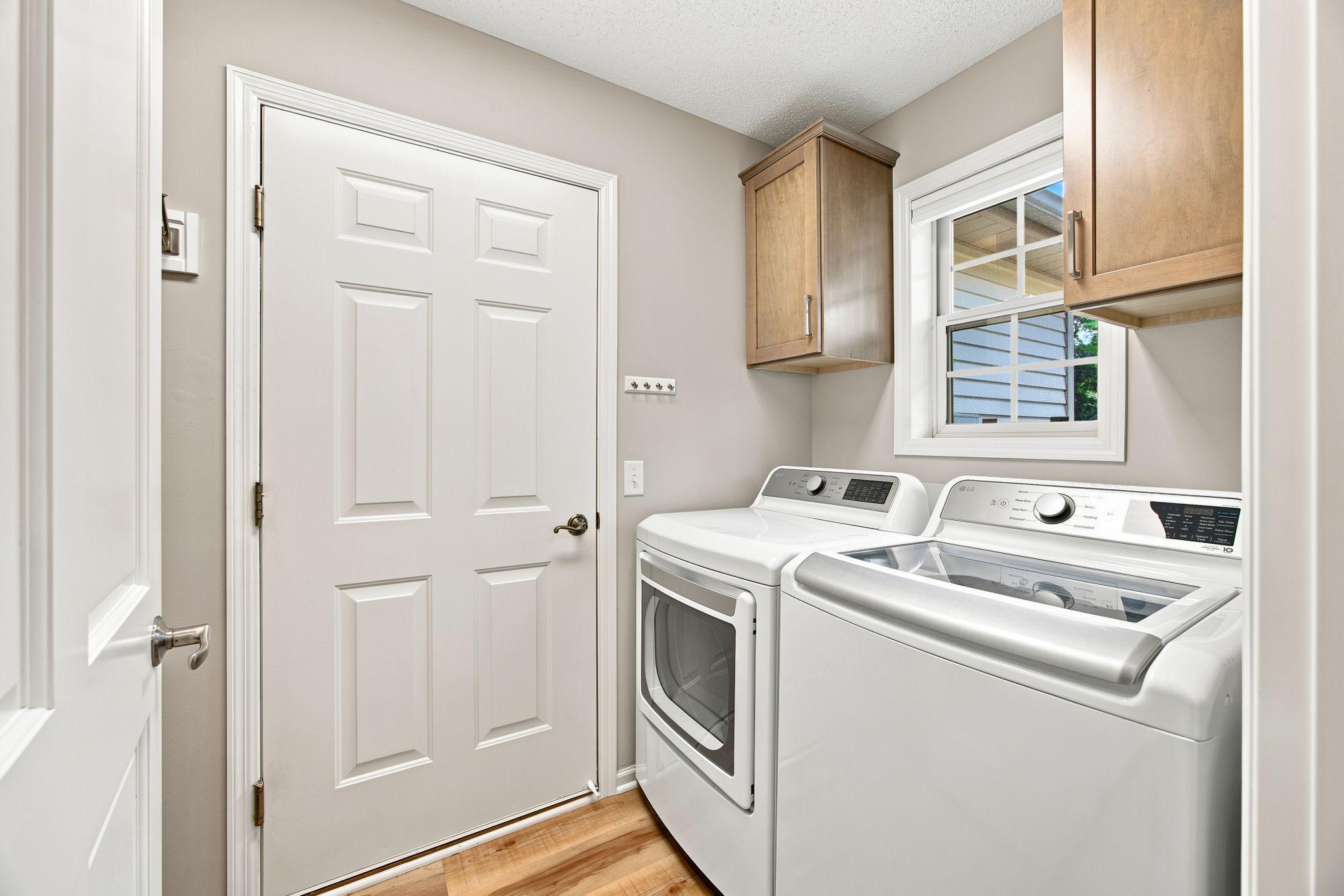 Just off the garage is the mud room LG washer and dryer, custom cabinets and delightful window.