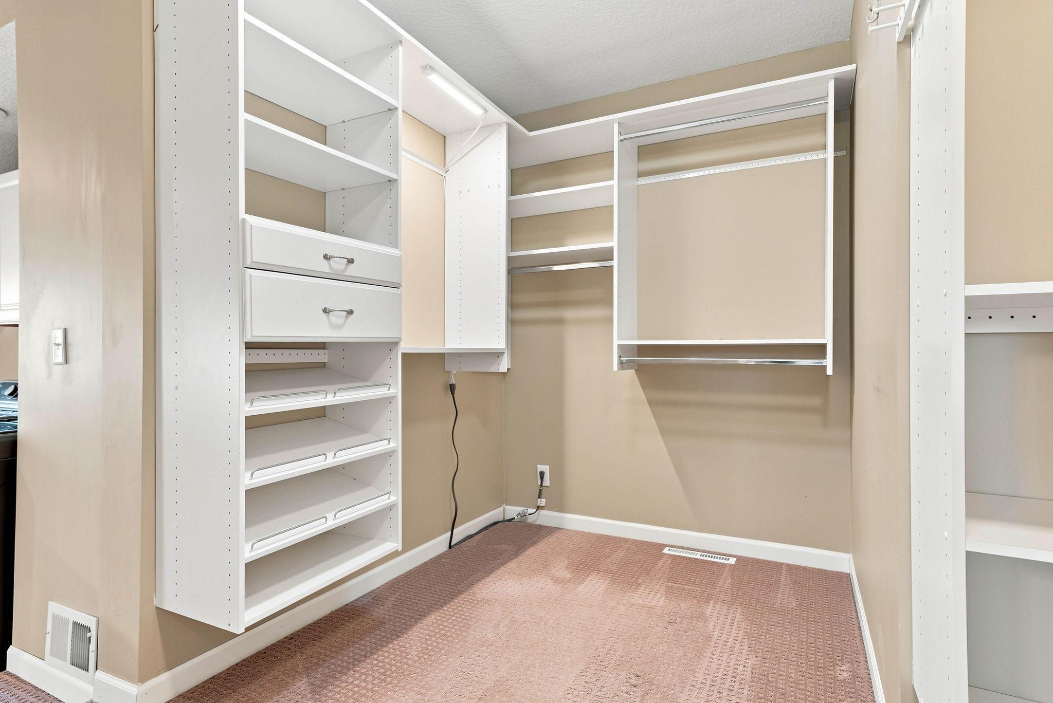 Second section of the walk in closet with custom closet organizers