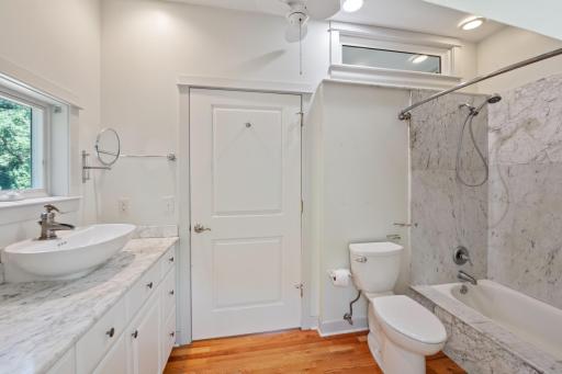 Upper level full bathroom features marble and hardwood floors.