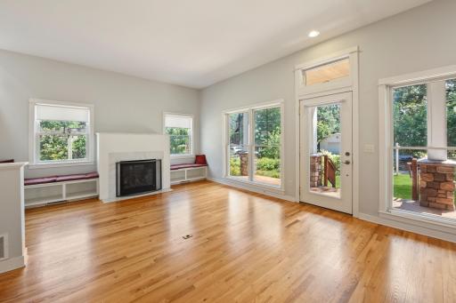Tons of natural light in this large open floor plan living room area with gas fireplace, beautiful hardwood floors and large windows.
