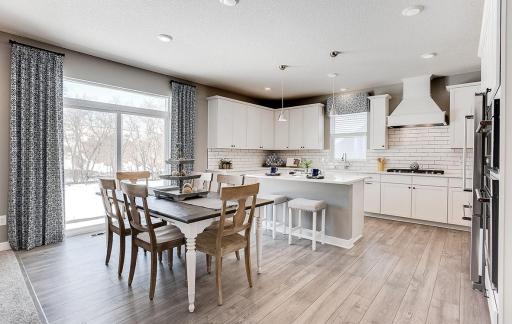 Wow, talk about natural light in this home! This kitchen features granite quartz countertops, a walk-in pantry & a spacious kitchen island! Photo of model home, color & options may vary.