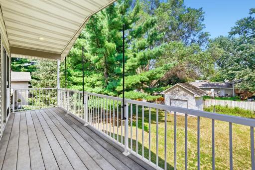 Fabulous covered deck overlooking fenced backyard with garden area and storage shed
