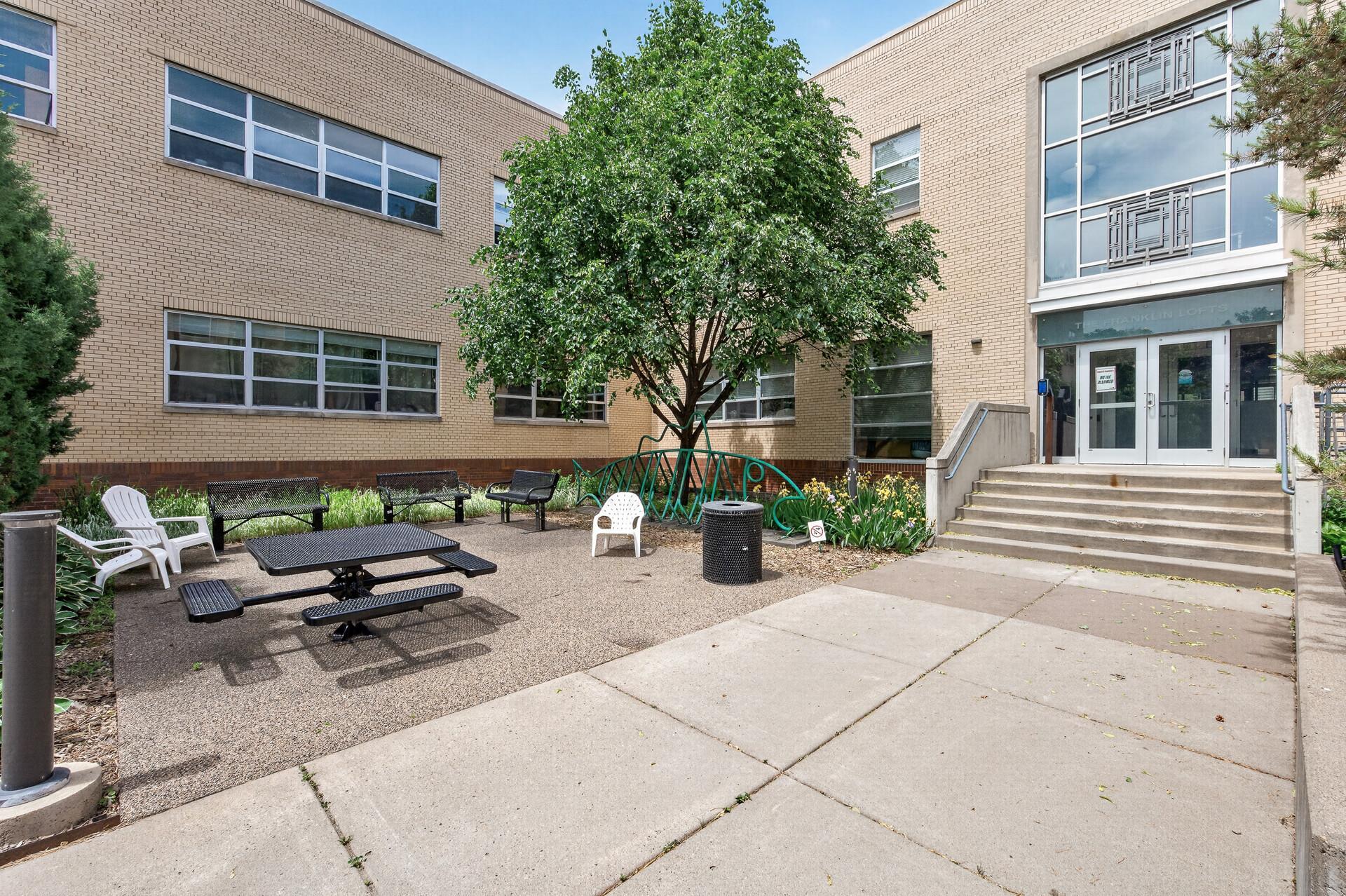 Views of the adjacent outdoor gathering area with the rear entrance other the main building.
