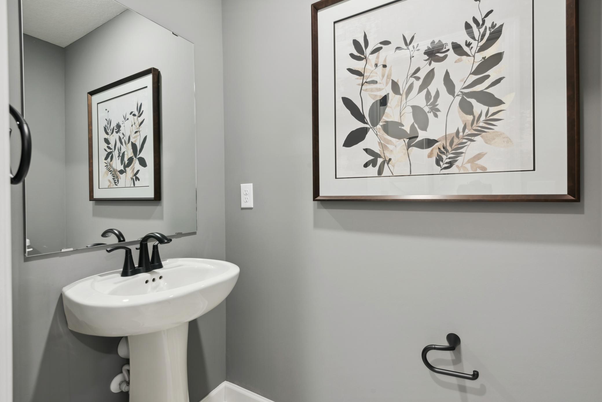 (Photo of a decorated model, actual homes finishes will vary) Conveniently located powder bath on the main level.