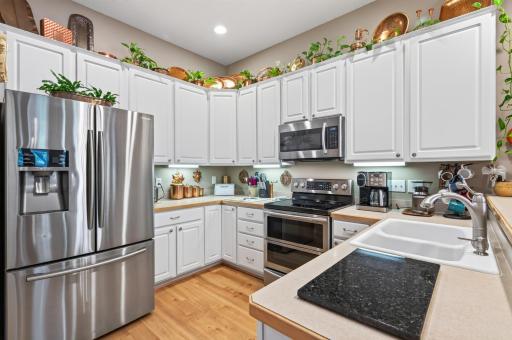 Spacious kitchen w/ LVP flooring, high raised panel cabinets and stainless steel appliances.