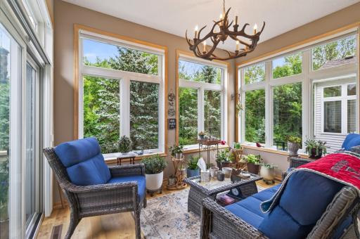 Relax in the sunroom with patio doors that bring you to your private deck. Private view of the wooded backyard .