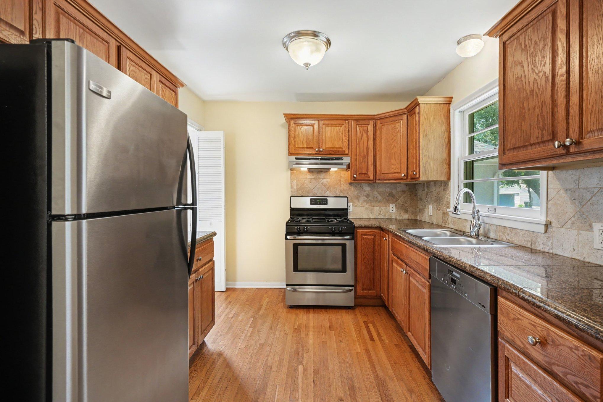 Updated kitchen with oak cabinets, stainless steel appliances, granite tile countertops, kitchen window & beautiful hardwood floors, and is freshly painted.