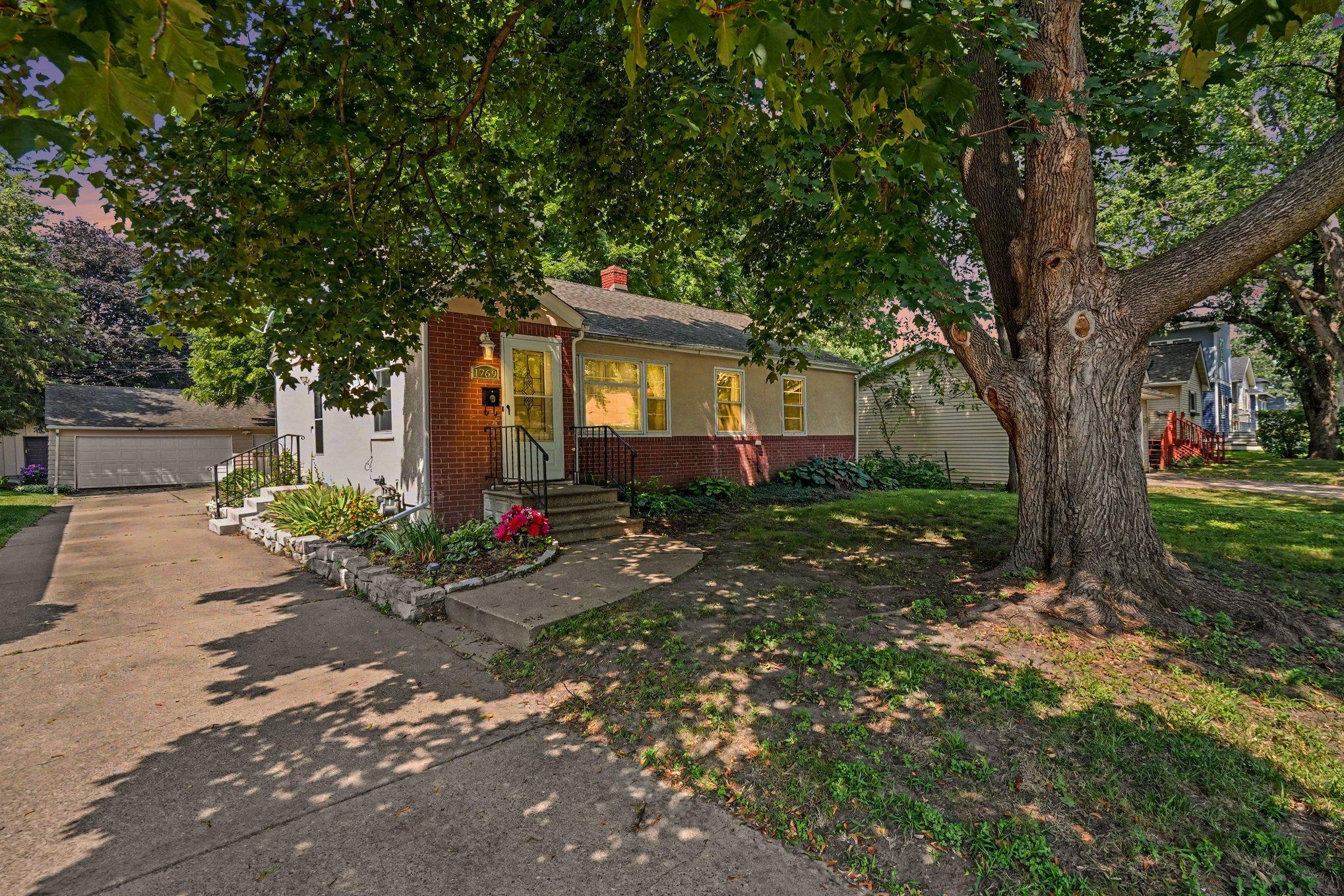 Charming brick and stucco rambler with a large detached 3-car garage, large mature trees with beautiful perennials!