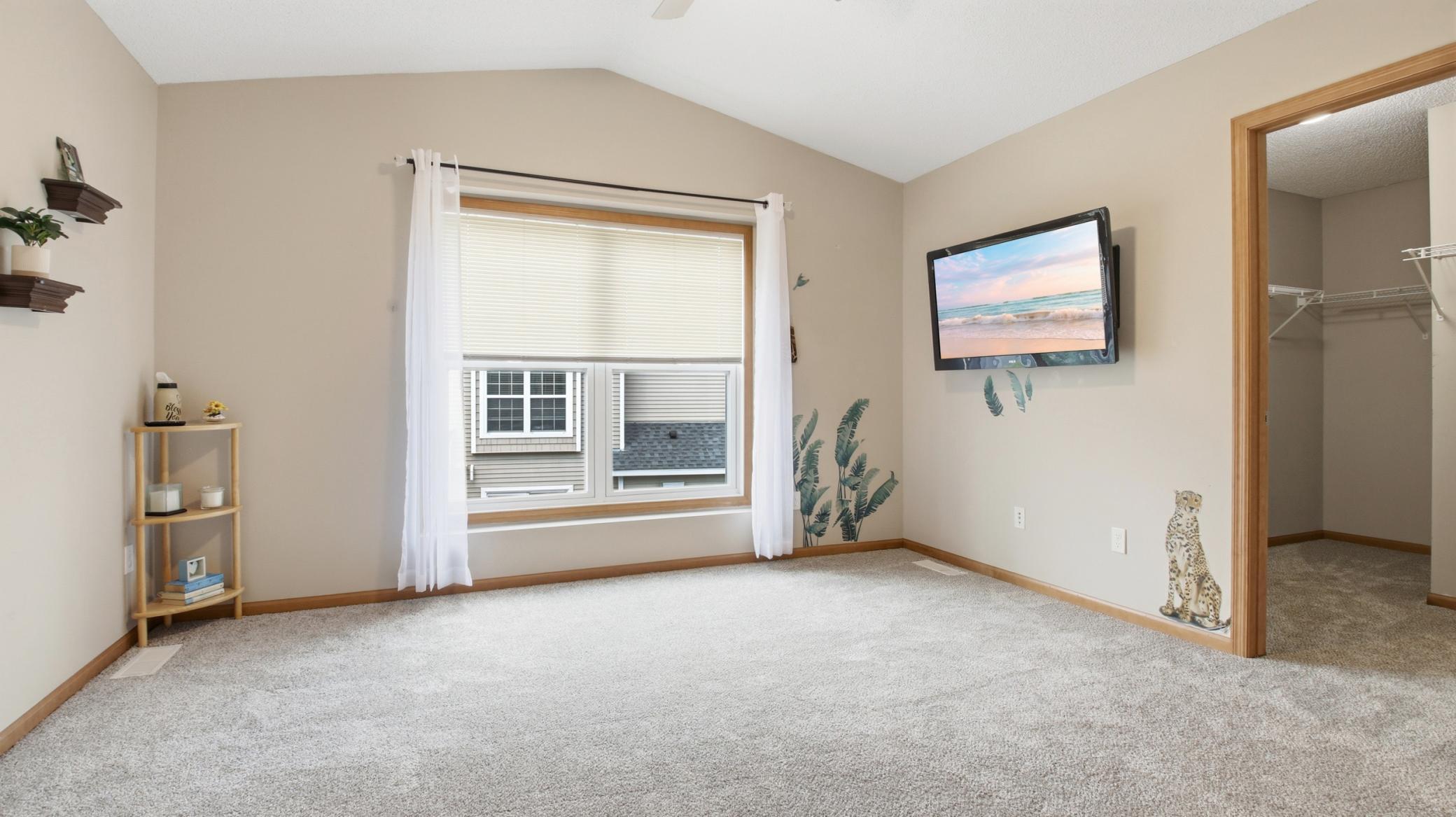 The spacious primary bedroom with a view of its large, walk-in closet.