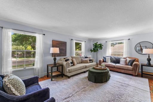 Hardwood floors and oversized windows create a warm, inviting first impression.