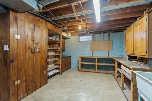Lower level also includes Whirlpool washer and dryer, a utility sink, and even more built-in storage and workbench for projects and organization.