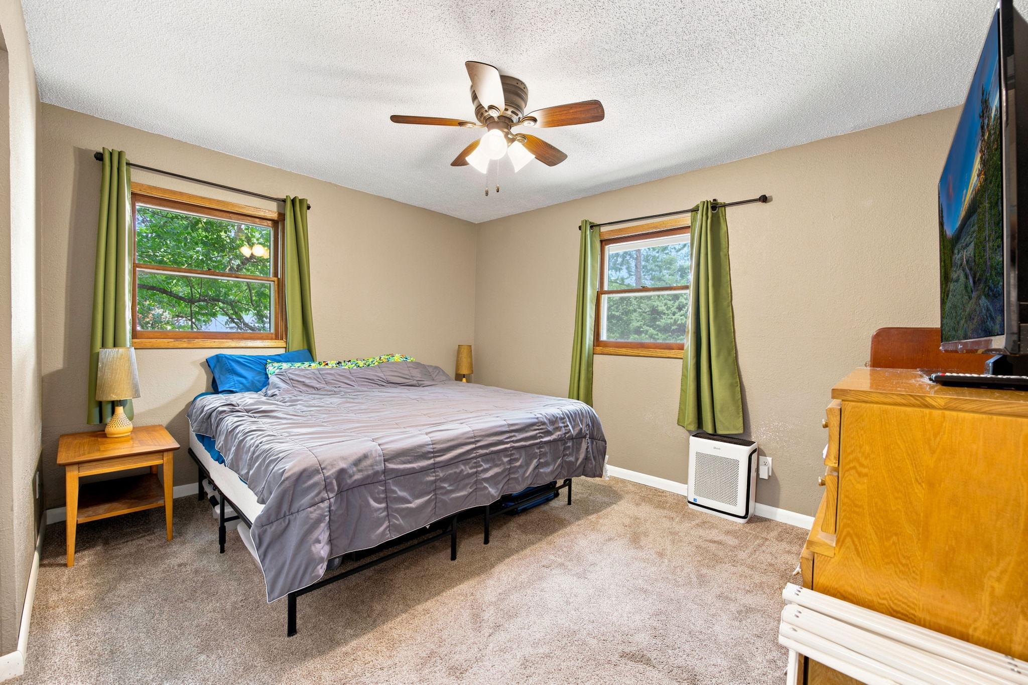 Two comfortable bedrooms on the main level, both with neutral finishes and peaceful wooded views