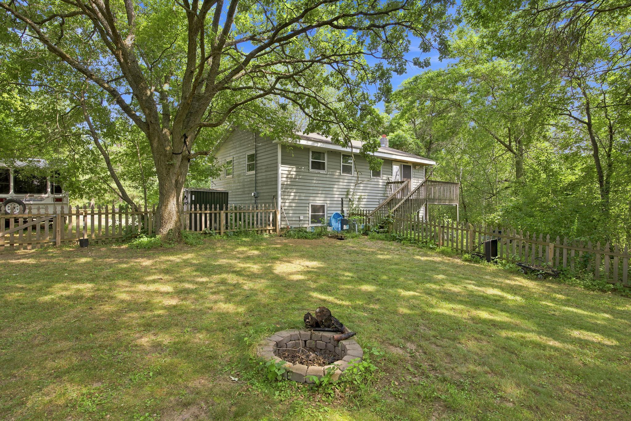 The backyard offers a deck, fenced space and a beautiful canopy of trees