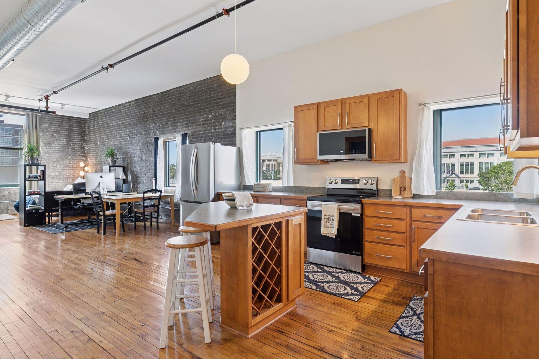 Open kitchen with wood cabinetry and stainless steel appliances