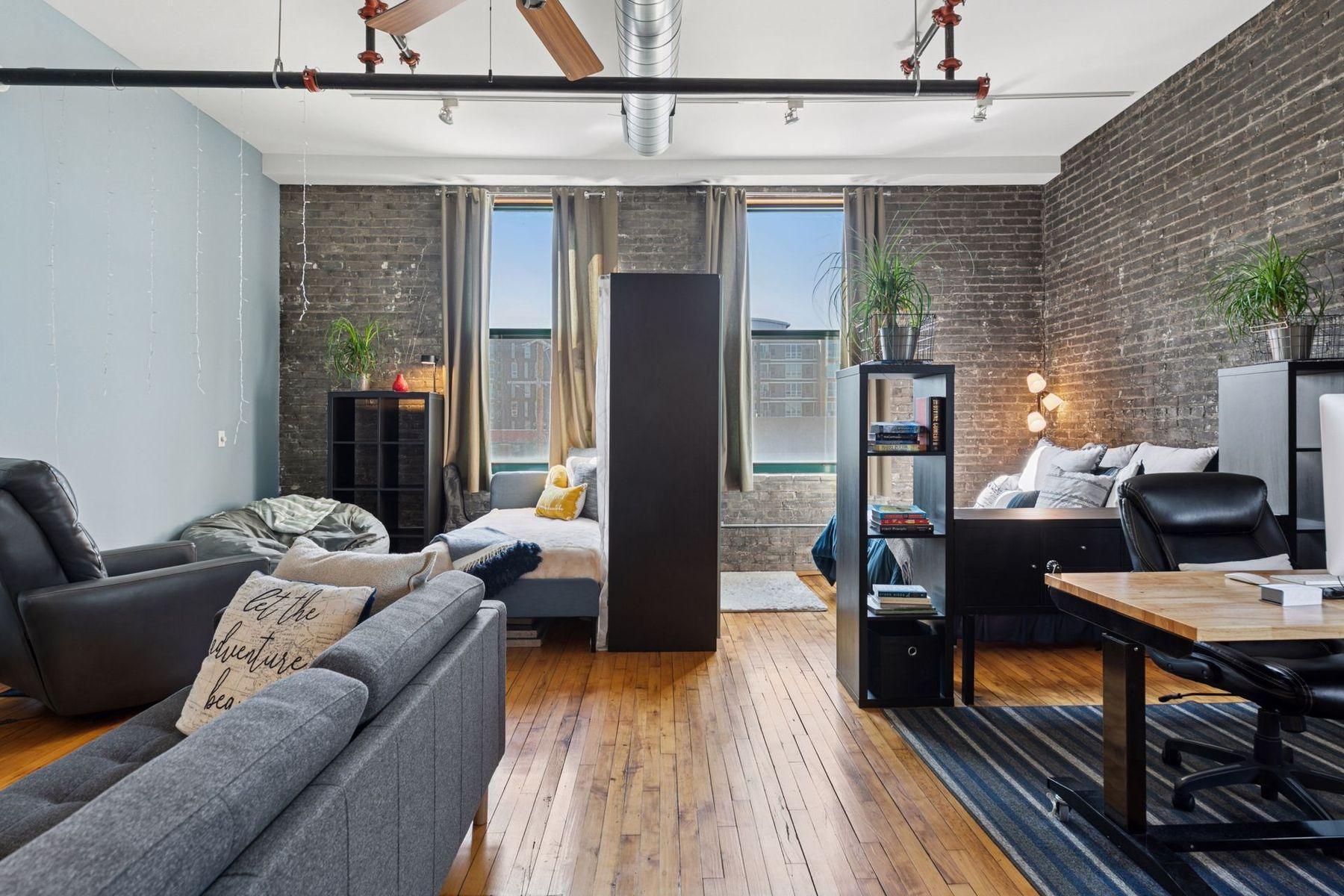 Spacious loft-style living with exposed brick, hardwood floors, and flexible layout — offered fully furnished for immediate move-in or rental use.