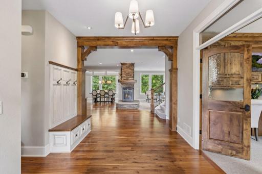 The inviting foyer features beautiful hickory hardwood floors, lovely knotty alder wood accents, a built-in bench with hooks and an office with beautiful French doors.