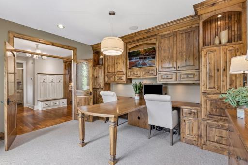 Another view of the office that highlights the beautiful knotty alder wood custom cabinets and dual desks.