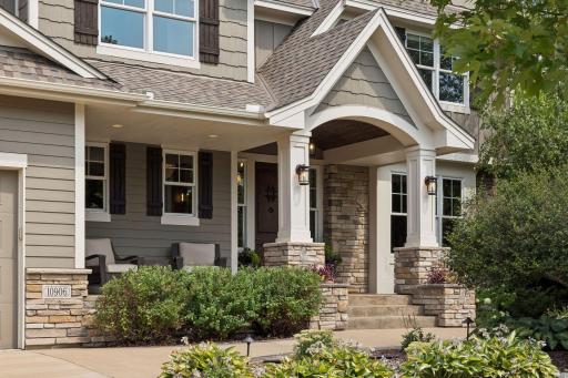 Another view of the front covered stamped concrete patio with decorative wooden barrel ceiling and beautiful wood front door.