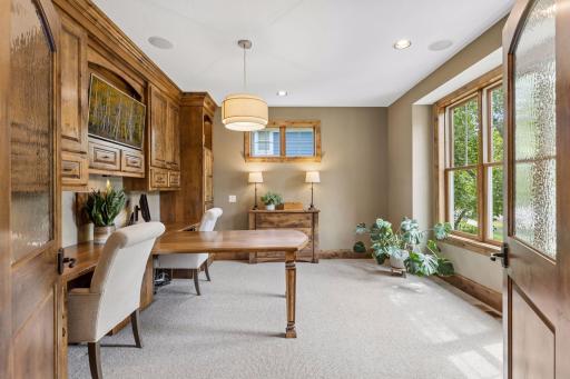The dedicated office features custom built-in cabinetry, dual desks and drawers, built-in speakers and recessed lights. The room is filled with natural light from the large front windows.