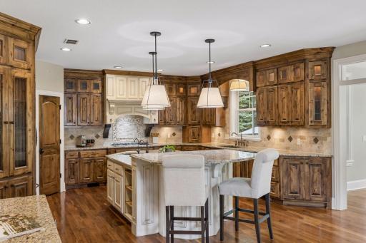 This well-equipped kitchen features a large center island with granite counters, storage & a prep sink. The space is perfect for entertaining with it's separate bar serving area with beverage refrigerator.