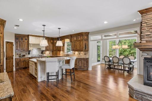 This view highlights the open flow between the kitchen and dining room. It showcases the beautiful hickory hardwood floors and the knotty alder wood custom cabinetry.
